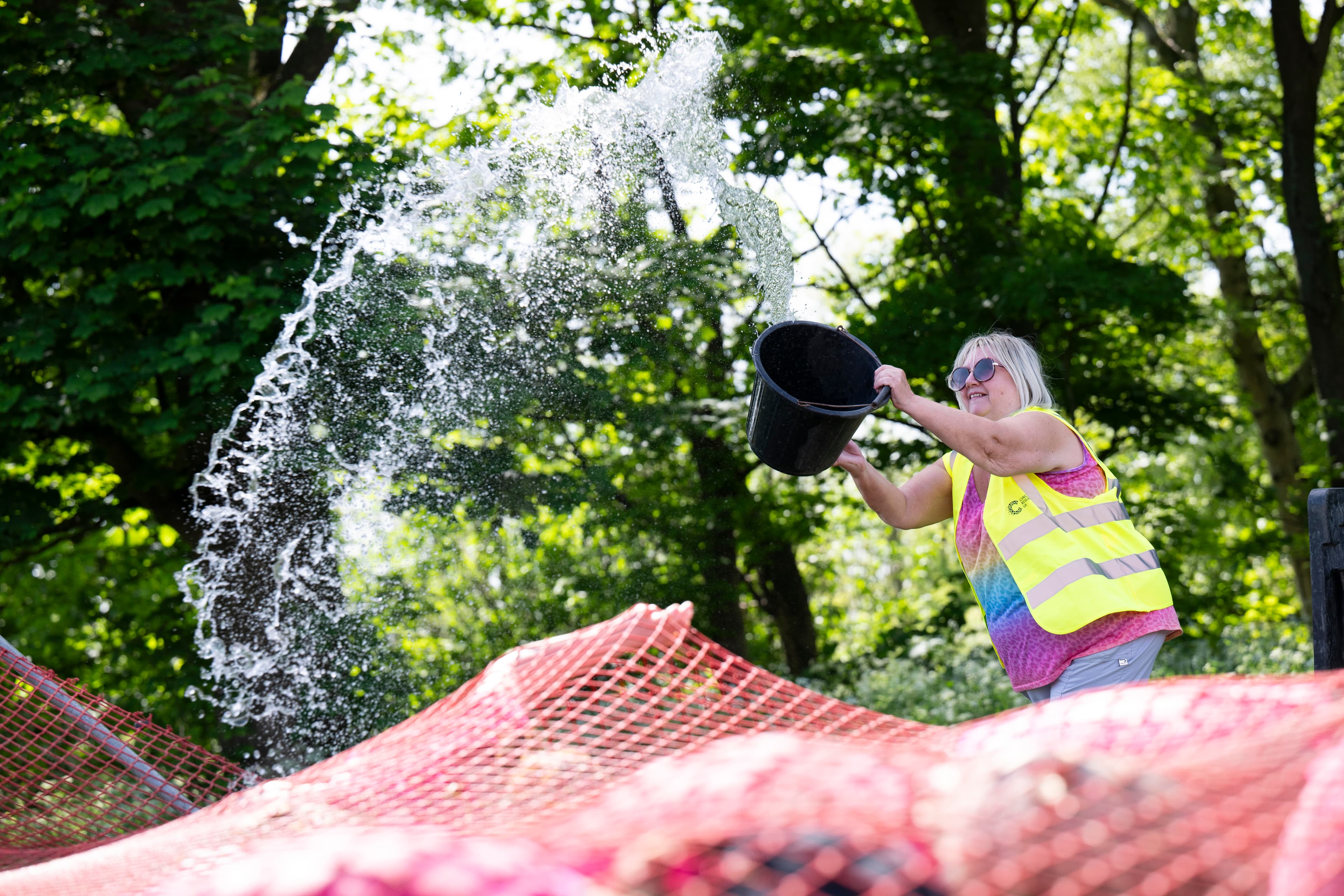 A Course Marshal is throwing a bucket of water.